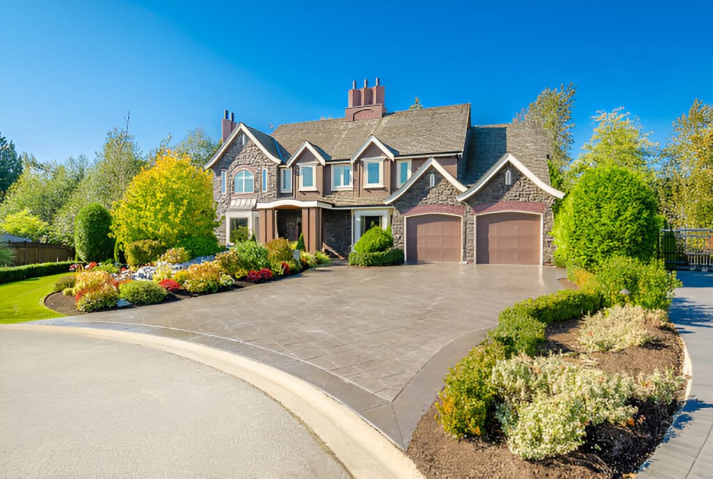 Modern residential neighborhood showcasing upscale contemporary homes surrounded by lush greenery, mature trees, and parked vehicles under a clear blue sky.